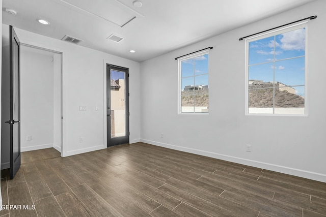 unfurnished bedroom featuring baseboards, visible vents, and dark wood-style flooring