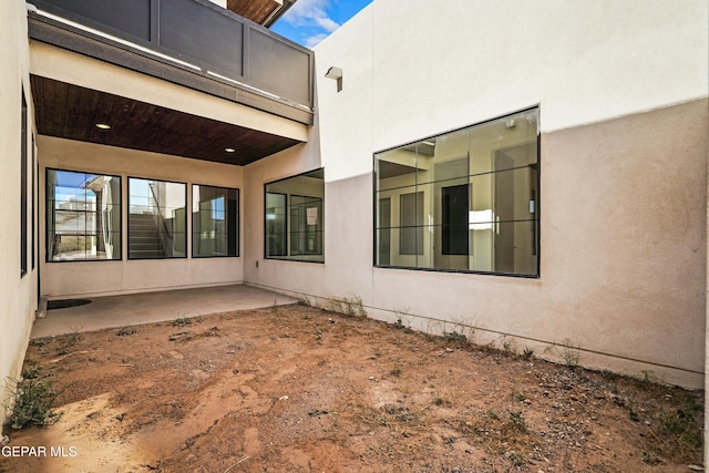 back of house with stucco siding and a patio area