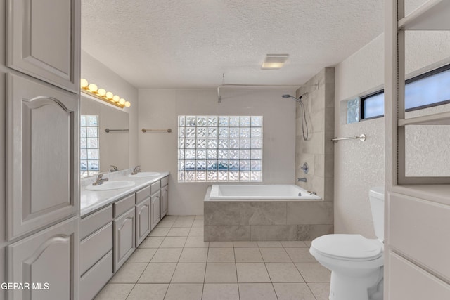 1003 Alethea Park Dr, El Paso, TX 79902 - full bath featuring a textured ceiling, a sink, tile patterned floors, toilet, and tiled shower / bath combo