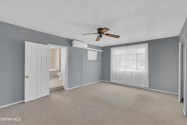 1003 Alethea Park Dr, El Paso, TX 79902 - unfurnished bedroom with baseboards, a wall mounted air conditioner, ensuite bath, and carpet flooring