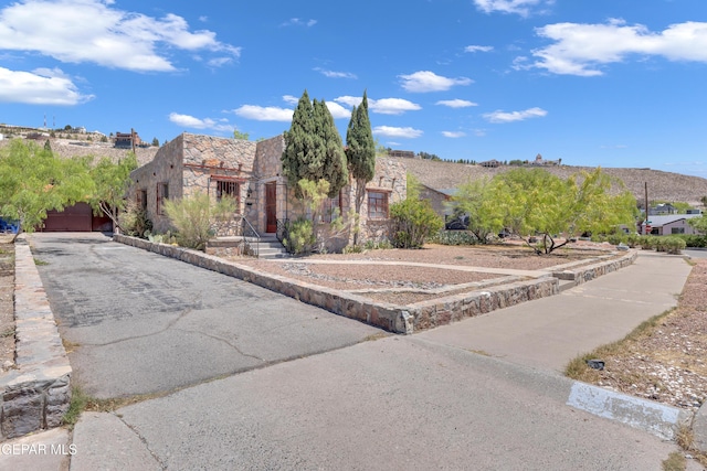 1003 Alethea Park Dr, El Paso, TX 79902 - view of front facade featuring an attached garage, driveway, and stone siding