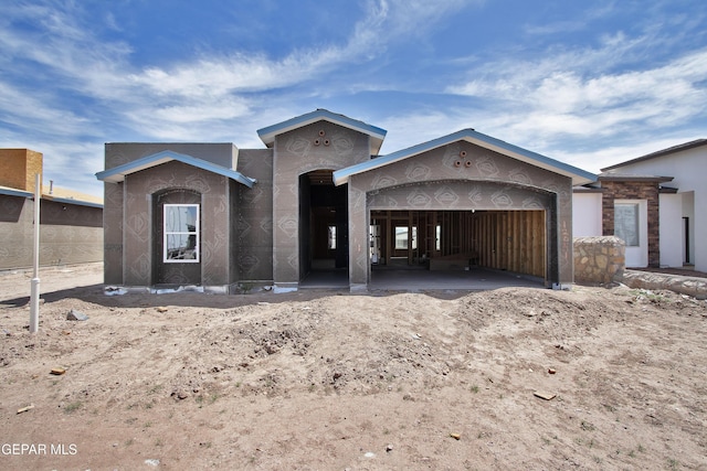 unfinished property with stucco siding and an attached garage