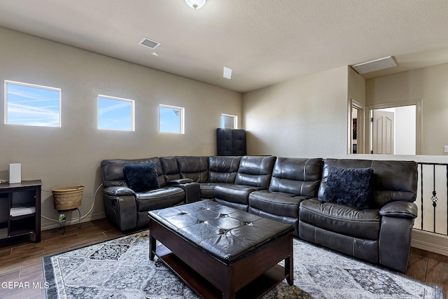 living area featuring visible vents, wood finished floors, and baseboards