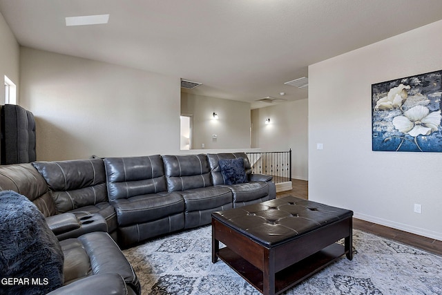 living room with visible vents, wood finished floors, and baseboards