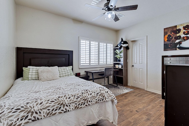 bedroom featuring a ceiling fan, wood finished floors, and baseboards
