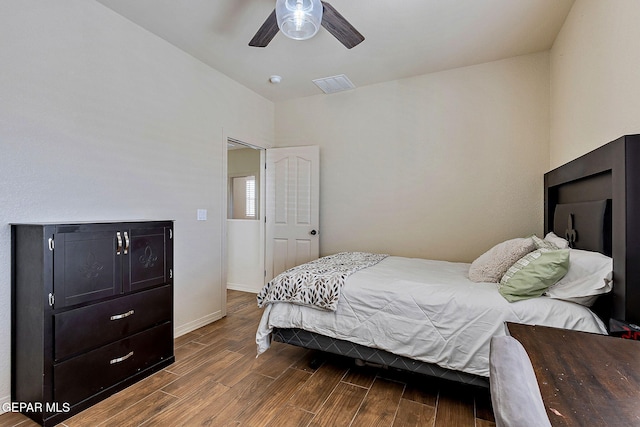 bedroom featuring a ceiling fan, visible vents, baseboards, and dark wood-type flooring