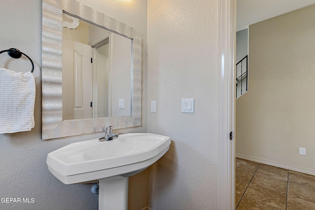 bathroom with baseboards and tile patterned floors