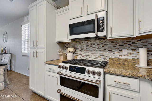 kitchen with white cabinetry, gas range oven, white microwave, and decorative backsplash