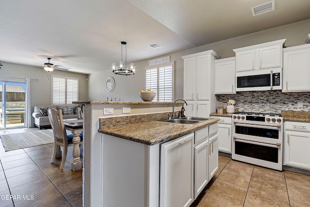 kitchen with white appliances, light tile patterned floors, white cabinets, a sink, and visible vents