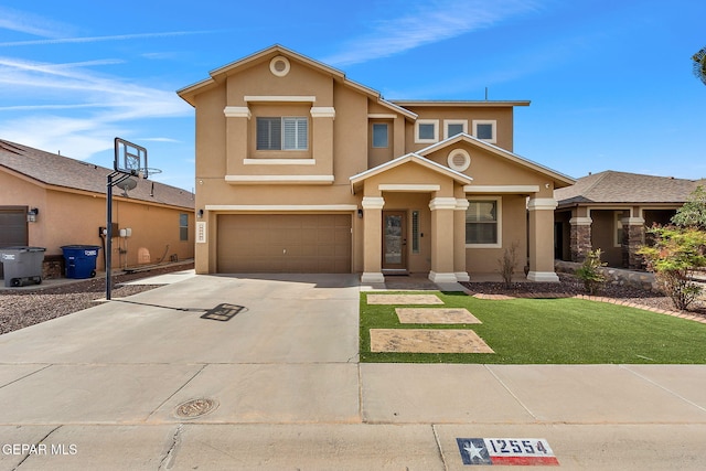 traditional-style home featuring stucco siding, driveway, a front yard, and a garage