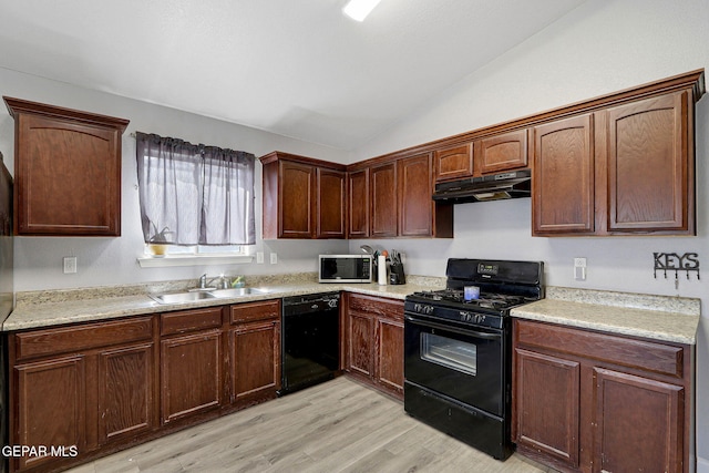 kitchen with lofted ceiling, light wood-type flooring, under cabinet range hood, a sink, and black appliances