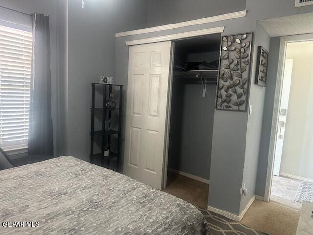 bedroom with a closet, baseboards, carpet floors, and visible vents