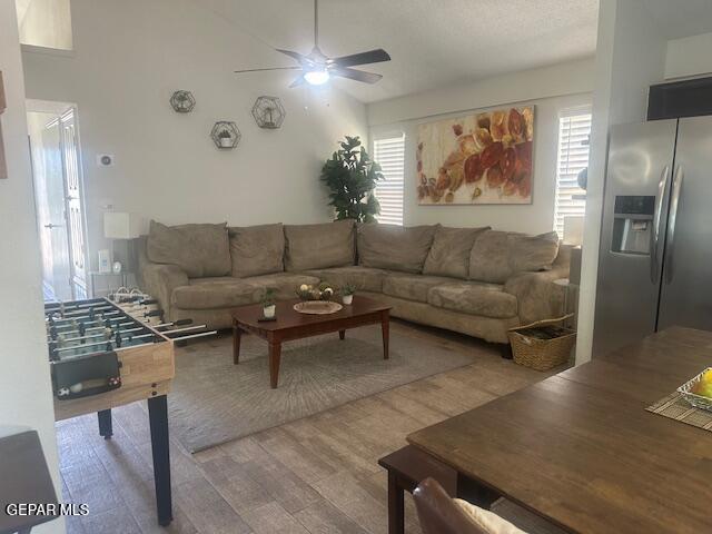 living area featuring a healthy amount of sunlight, a ceiling fan, and wood finished floors