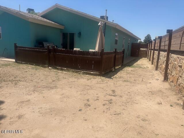 back of property featuring stucco siding and fence