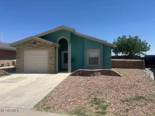 ranch-style house with an attached garage and concrete driveway
