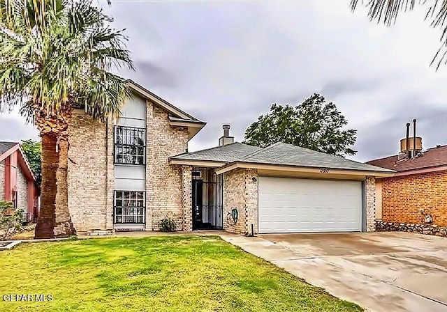 split level home featuring a garage, driveway, brick siding, and a front yard