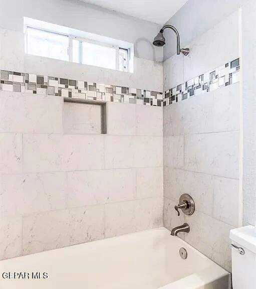 bathroom featuring shower / bathing tub combination and toilet