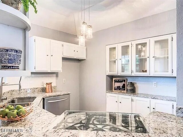 kitchen featuring stainless steel dishwasher, pendant lighting, glass insert cabinets, white cabinetry, and light stone counters