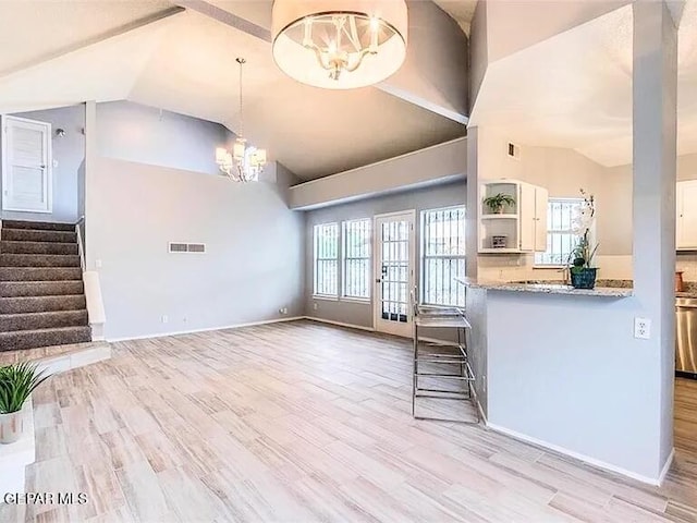 kitchen featuring high vaulted ceiling, a notable chandelier, plenty of natural light, and visible vents