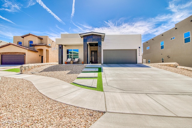 adobe home with driveway and a garage