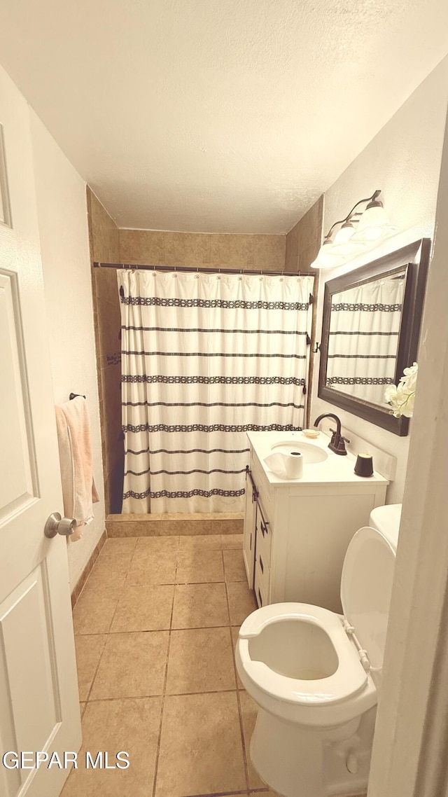 full bath with toilet, tile patterned floors, a textured ceiling, and vanity