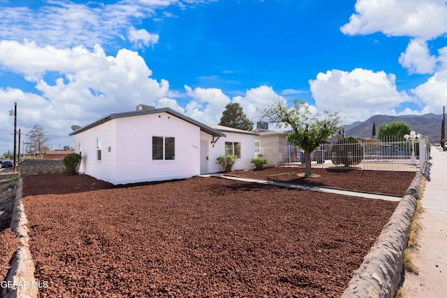 ranch-style home with a mountain view and fence