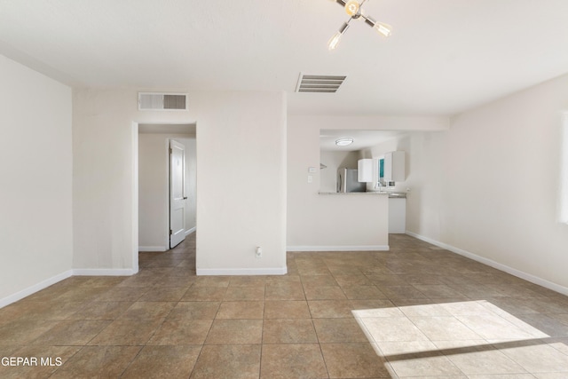 unfurnished living room featuring visible vents and baseboards
