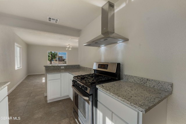 kitchen featuring an inviting chandelier, island exhaust hood, tile patterned floors, visible vents, and gas stove