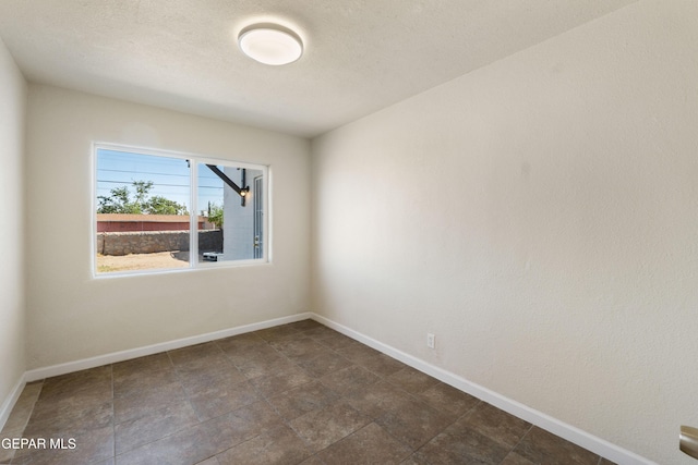 spare room featuring baseboards