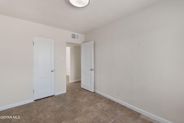 unfurnished bedroom featuring visible vents and baseboards