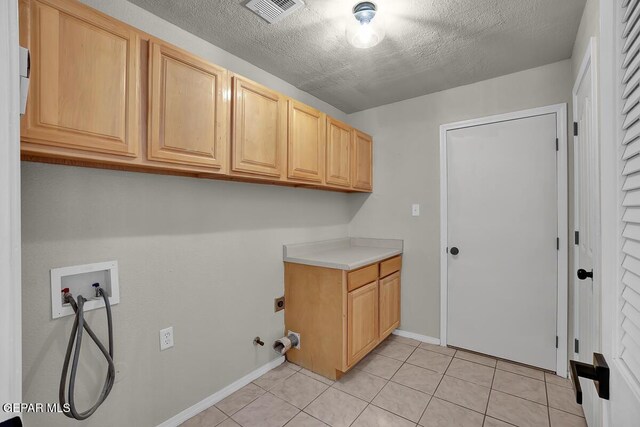 12617 Sun Spirit Dr, El Paso, TX 79938 - laundry area with cabinet space, hookup for a washing machine, light tile patterned floors, baseboards, and a textured ceiling