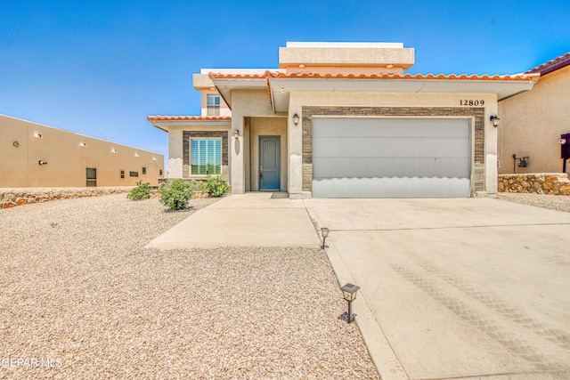mediterranean / spanish-style home with concrete driveway, an attached garage, a tile roof, and stucco siding