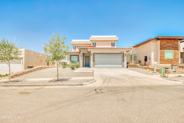 view of front of property featuring an attached garage, concrete driveway, stucco siding, and a tiled roof
