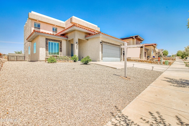 view of front facade with a tiled roof, a garage, fence, concrete driveway, and stucco siding