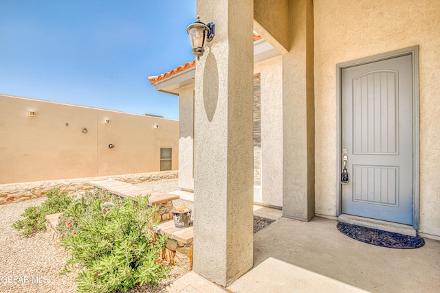 view of exterior entry featuring stucco siding