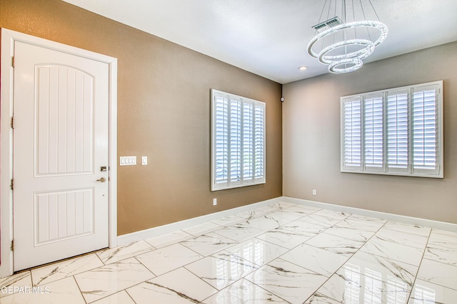 spare room featuring an inviting chandelier, recessed lighting, baseboards, and marble finish floor