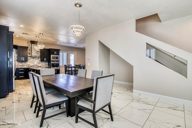 dining space featuring recessed lighting, baseboards, an inviting chandelier, and marble finish floor