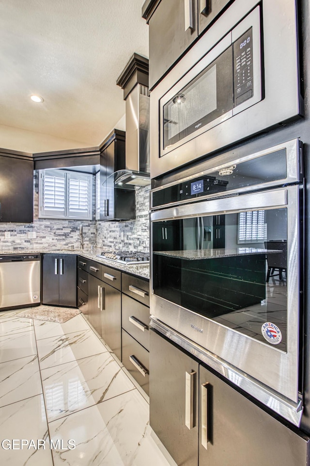 kitchen featuring appliances with stainless steel finishes, decorative backsplash, a sink, and marble finish floor