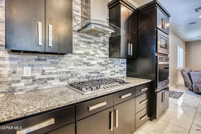 kitchen featuring visible vents, decorative backsplash, marble finish floor, wall chimney exhaust hood, and stainless steel appliances