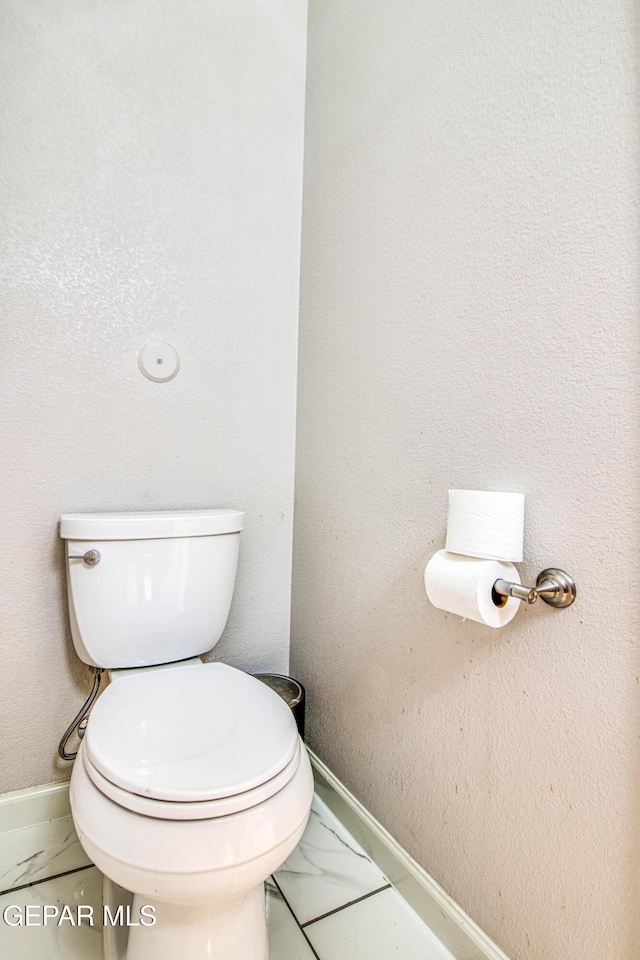 bathroom with toilet and baseboards