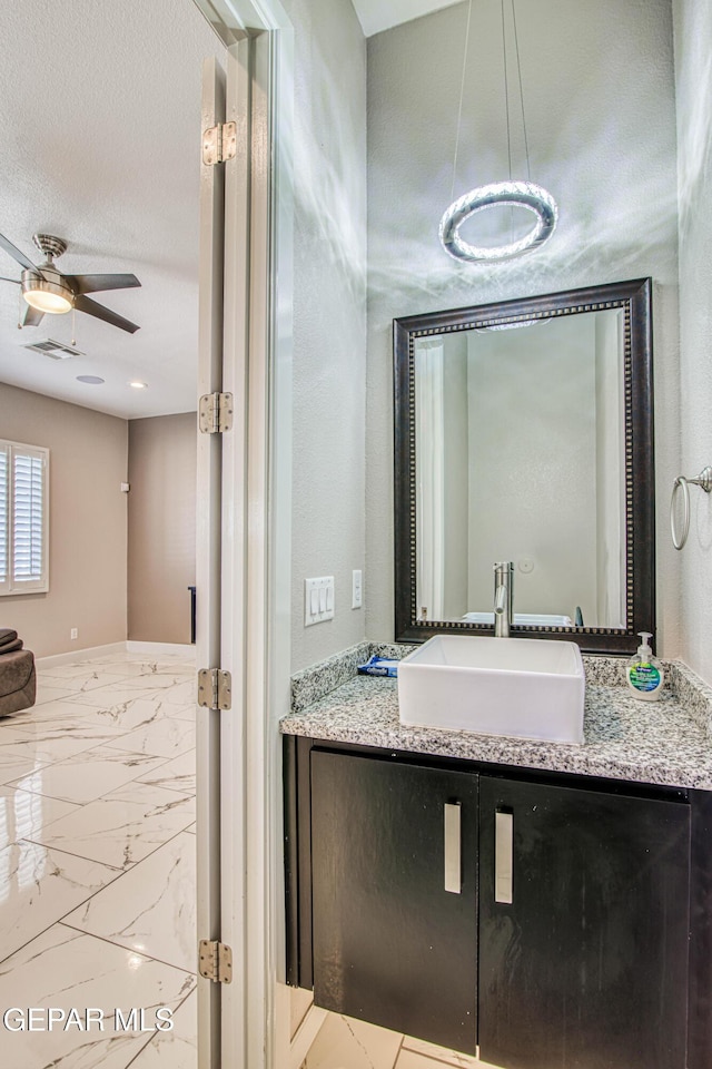 bathroom featuring a ceiling fan, visible vents, marble finish floor, and vanity