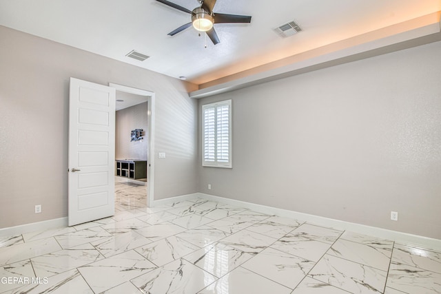 empty room featuring visible vents, a ceiling fan, baseboards, and marble finish floor