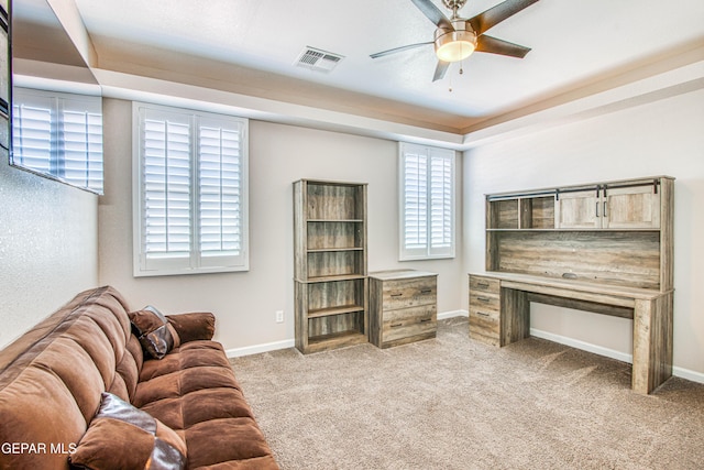living room featuring a ceiling fan, visible vents, baseboards, carpet, and a wealth of natural light