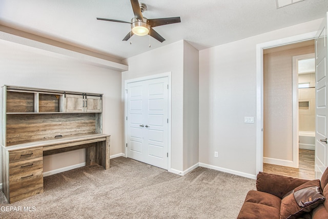office space with baseboards, ceiling fan, and light colored carpet