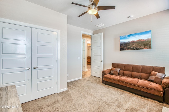 living room featuring a ceiling fan, baseboards, visible vents, and light carpet