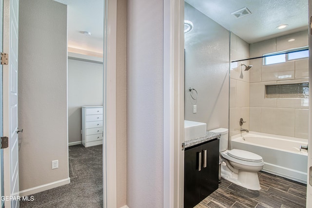 bathroom with vanity, toilet, shower / washtub combination, wood finished floors, and visible vents