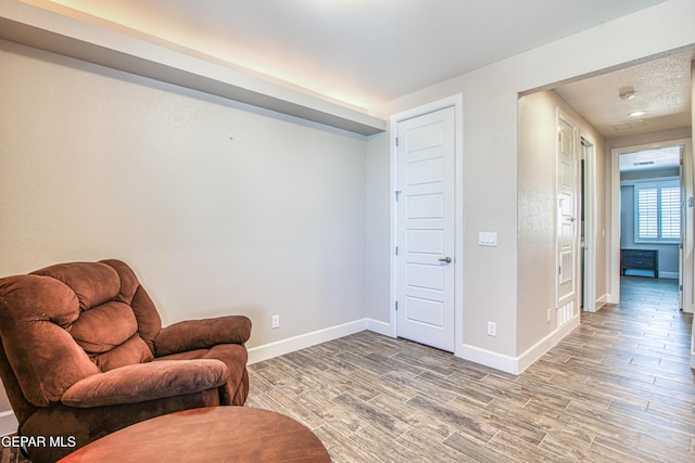 sitting room with baseboards and light wood-style floors