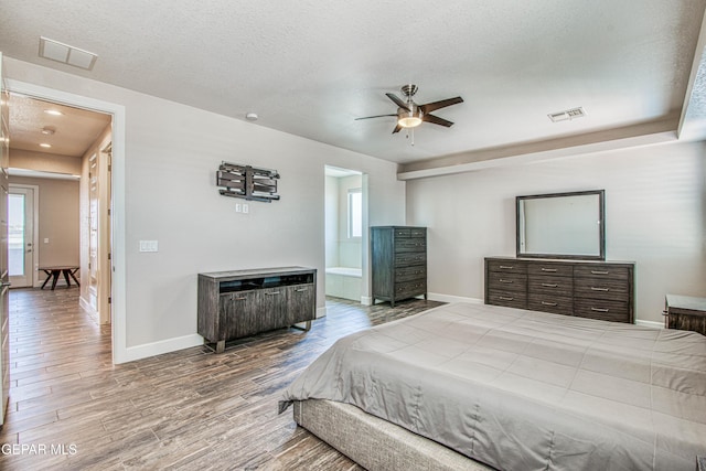 bedroom featuring visible vents, multiple windows, and wood finished floors