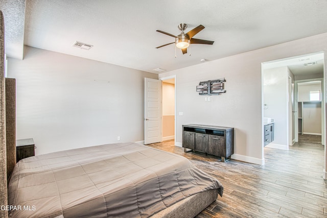 bedroom featuring visible vents, a ceiling fan, baseboards, and wood finished floors