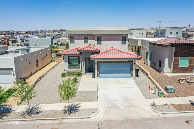 mediterranean / spanish house with a garage, stucco siding, a tiled roof, concrete driveway, and a residential view